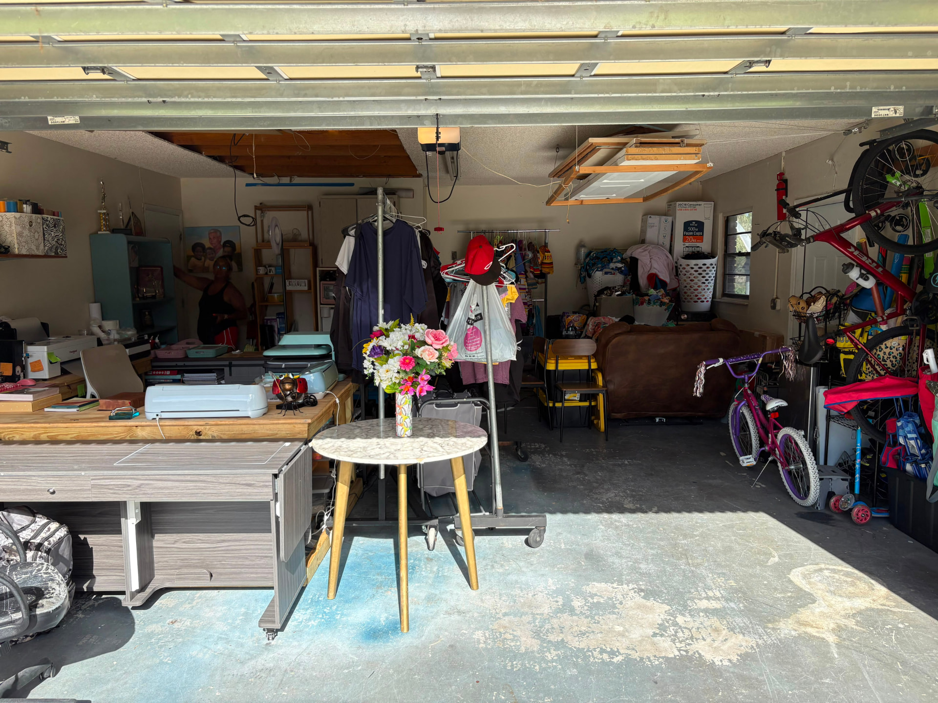 After — This busy client runs her small business from the garage but had no room to work. In a single day we built her a dedicated workspace with a clear craft and project station, plus organized zones for clothing, sports gear, bikes, tools, and everyday storage — so she can sit down and start working the moment she walks in.