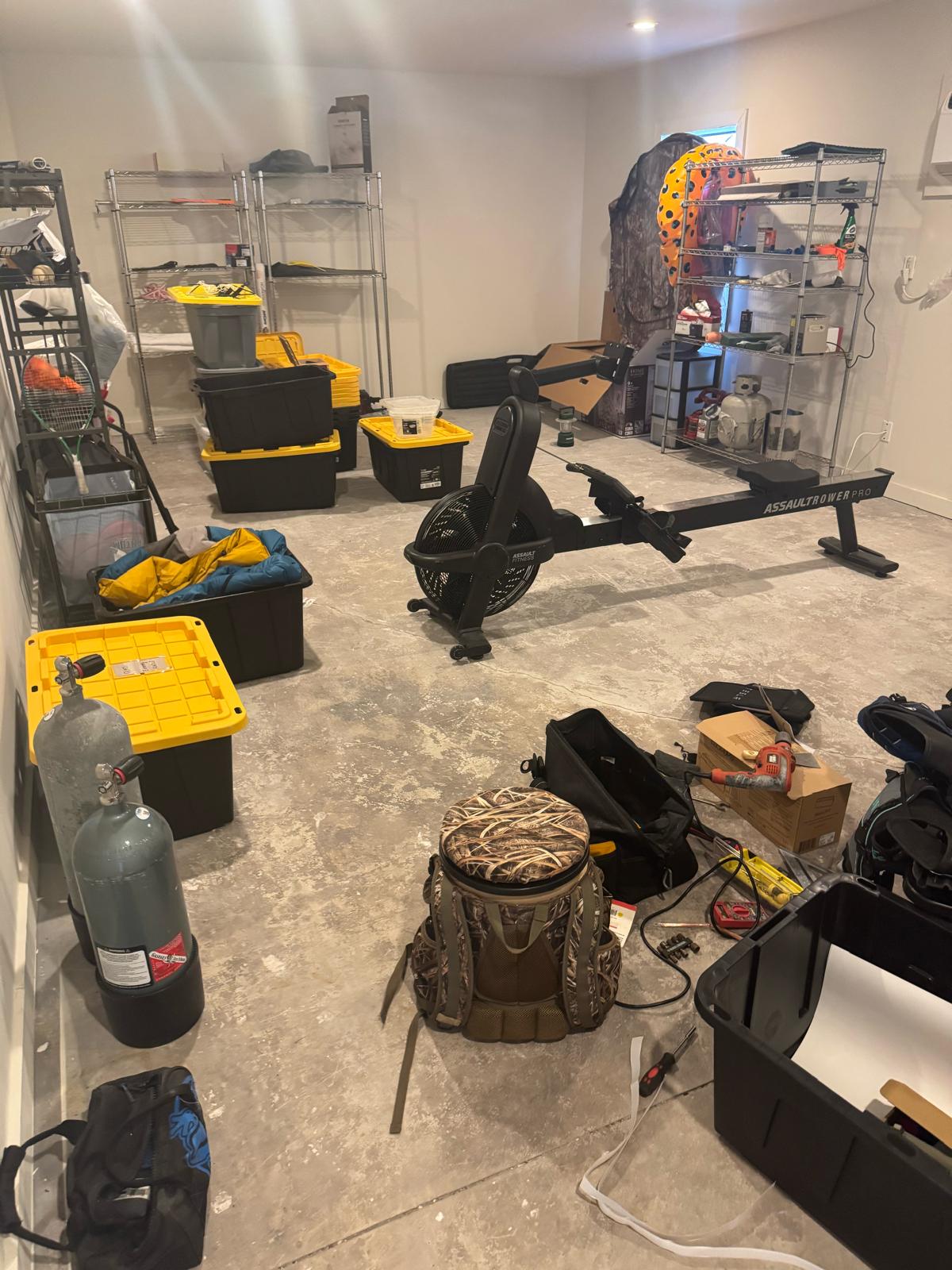 Before — Custom man cave and fitness garage with epoxy flooring, built-in storage, and organized zones for equipment, tools, and everyday gear.